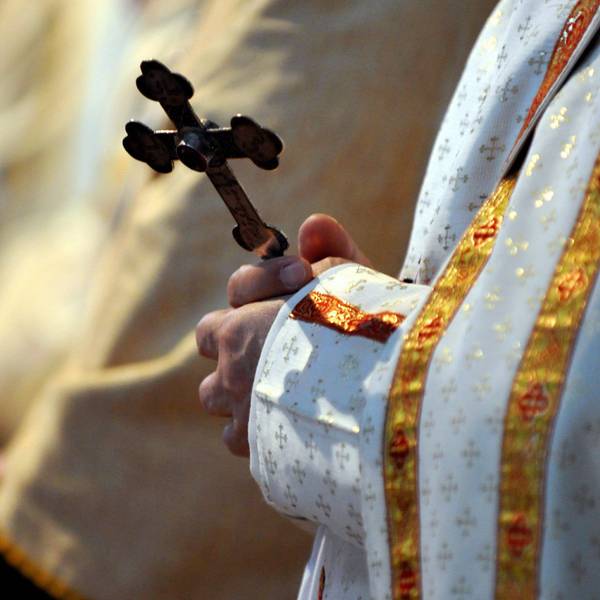 Ein Bischof hält während einer katholischen Messe ein Kreuz in den Händen.