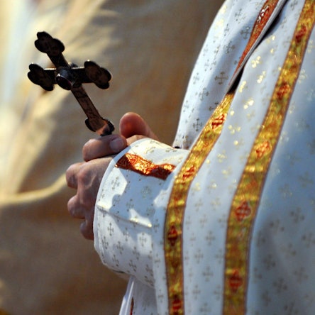 Ein Bischof hält während einer katholischen Messe ein Kreuz in den Händen.