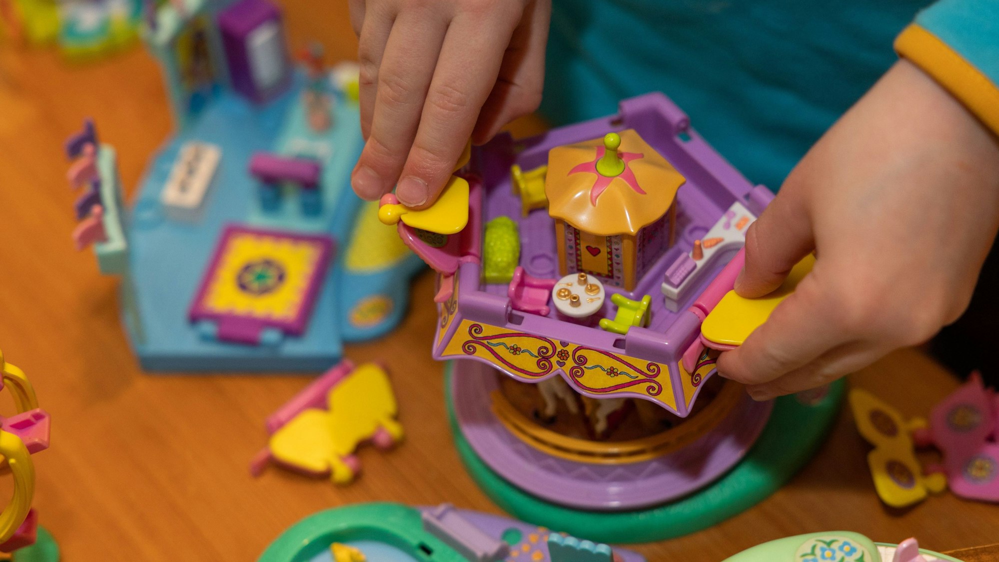 Kinderhände greifen nach einem Modell der Spielzeugserie Polly Pocket