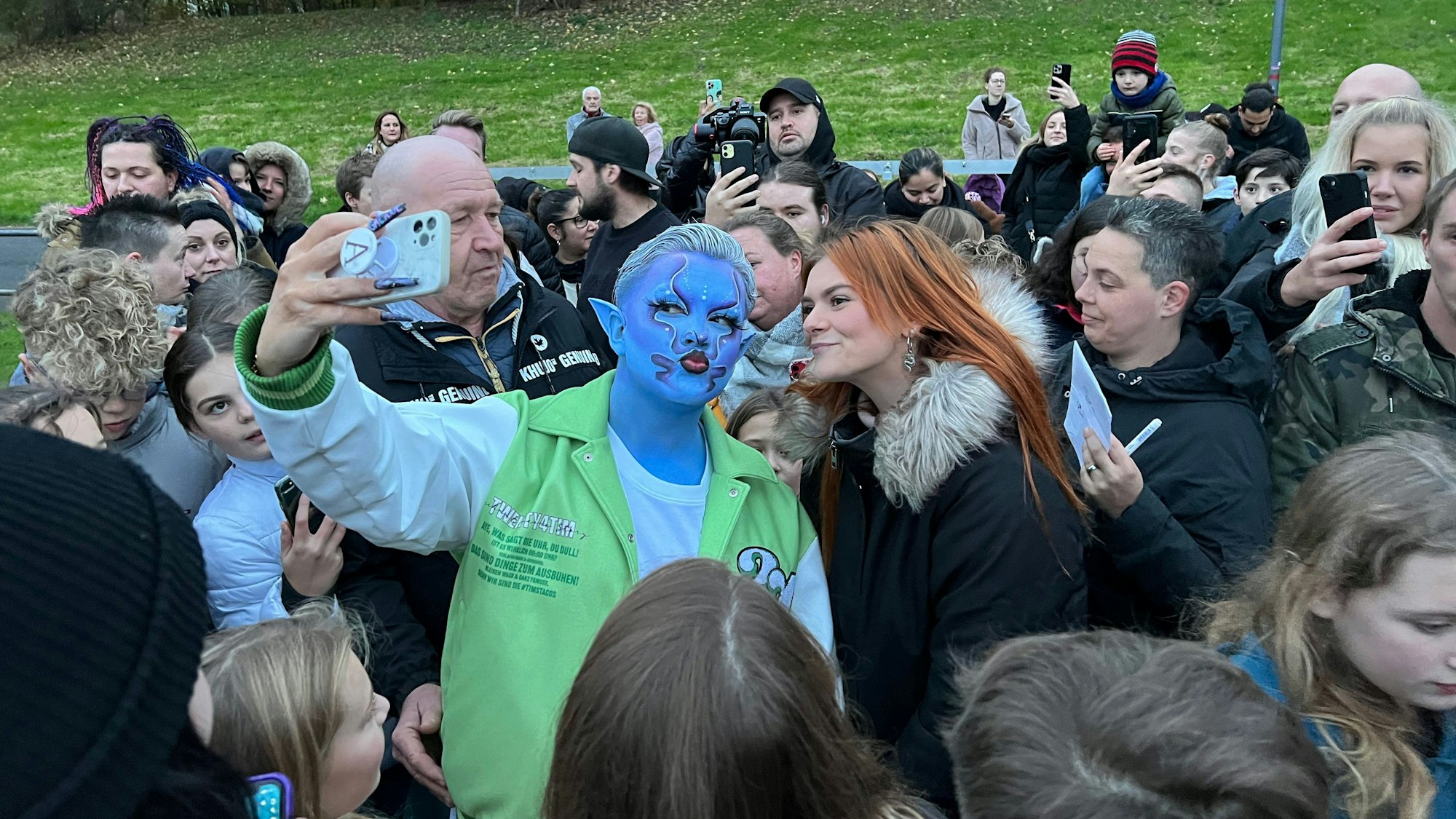Der Kölner Influencer und twenty4tim macht mit einem Fan ein Selfie.