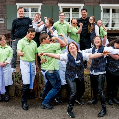 Die Sankt Augustinerin Nicola Gaebel (hintere Reihe, zweite von rechts) war in einem TV-Format mit Tim Mälzer zu sehen. Der Auftritt verhalf der 19-Jährigen mit Down-Syndrom zu ihrem Traumjob.