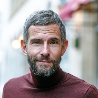 Der Journalist und Autor Micky Beisenherz steht in seinem Wohnviertel auf der Straße.