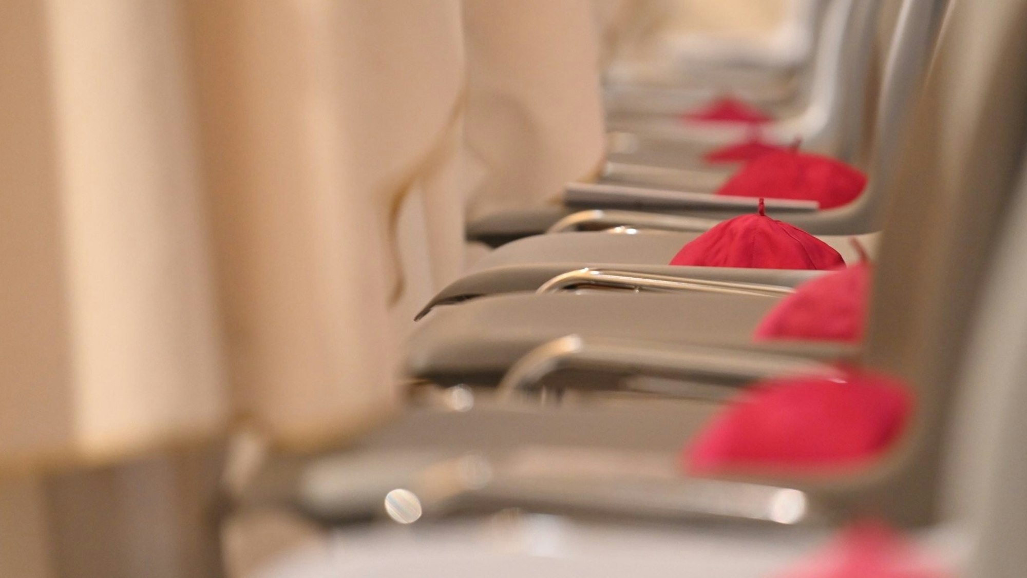 Violette Bischofskappen liegen auf Stühlen in der römischen Kirche San Giovanni in Laterano. Die deutschen katholischen Bischöfe haben eine Reform des kirchlichen Arbeitsrechts beschlossen.