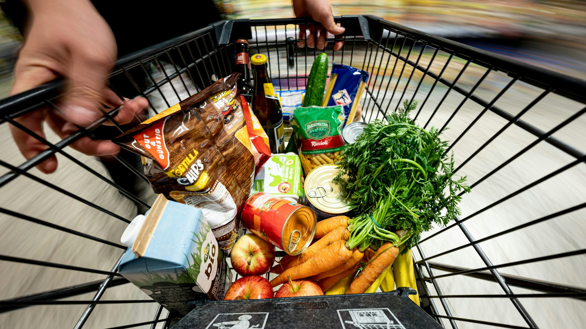 26.08.2022, Berlin: Ein Einkauf liegt in einem Einkaufswagen in einem Supermarkt. Die Menschen in Deutschland lassen beim Einkauf im Supermarkt oder beim Discounter angesichts der hohen Preissteigerungen immer häufiger Markenartikel links liegen und greifen lieber zu den preisgünstigeren Eigenmarken der Handelsketten.
Auch beim Einkaufen versuchen viele Leute gerade zu sparen. (zu dpa: «Wenn Sparen auf die Stimmung drückt») Foto: Fabian Sommer/dpa - Honorarfrei nur für Bezieher des Dienstes dpa-Nachrichten für Kinder +++ dpa-Nachrichten für Kinder +++
