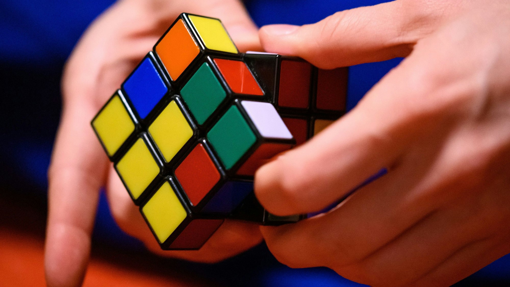 Eine junge Frau spielt mit einem Zauberwürfel.