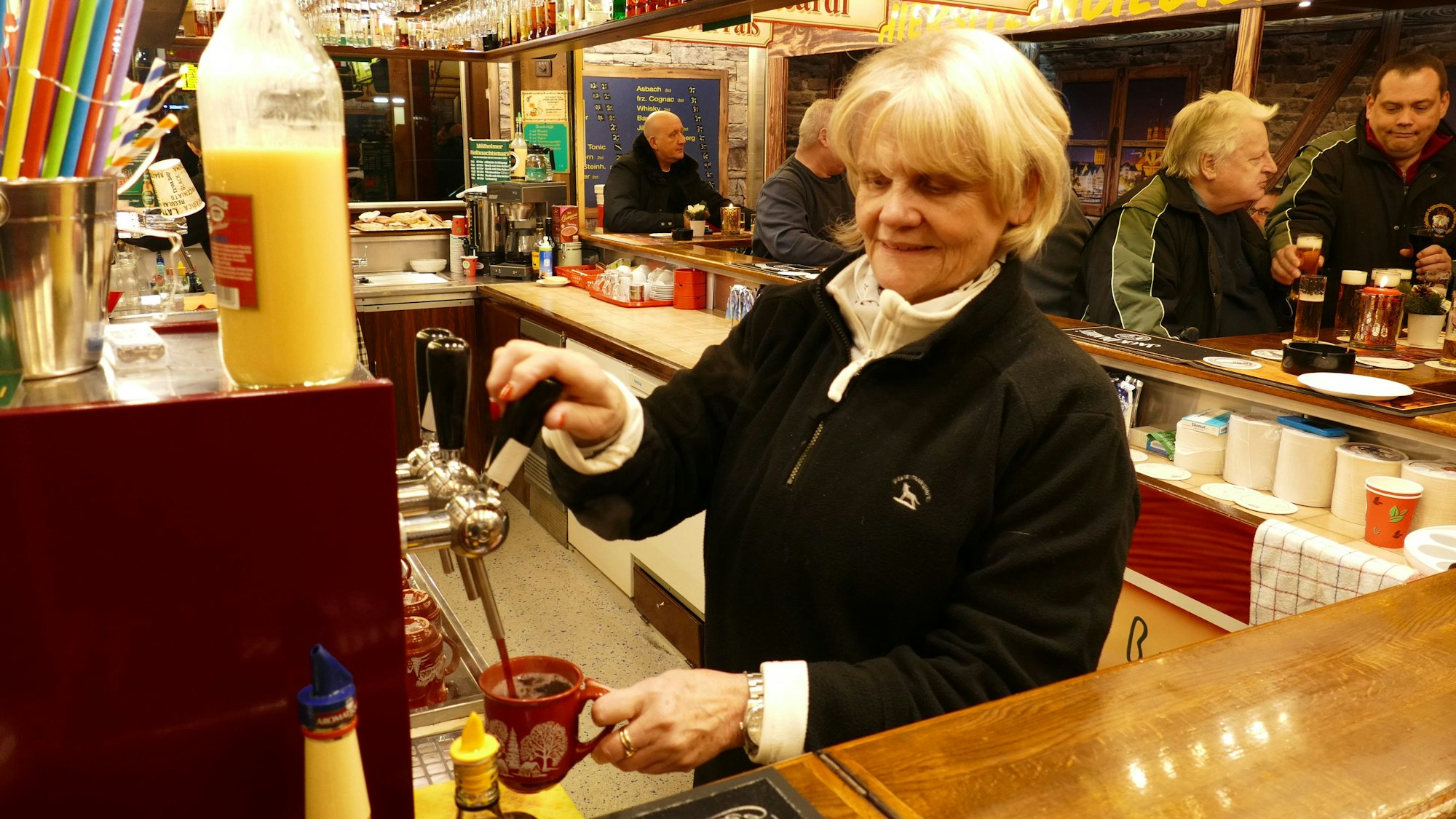 Marianne Krämer füllt Glühwein in eine Tasse.