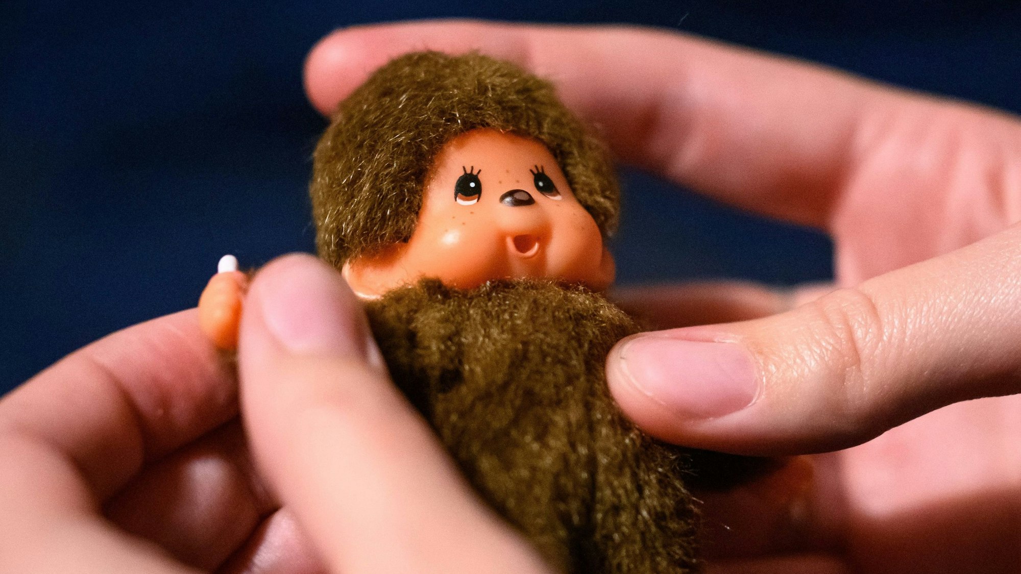 Eine junge Frau spielt mit einem Monchichi.