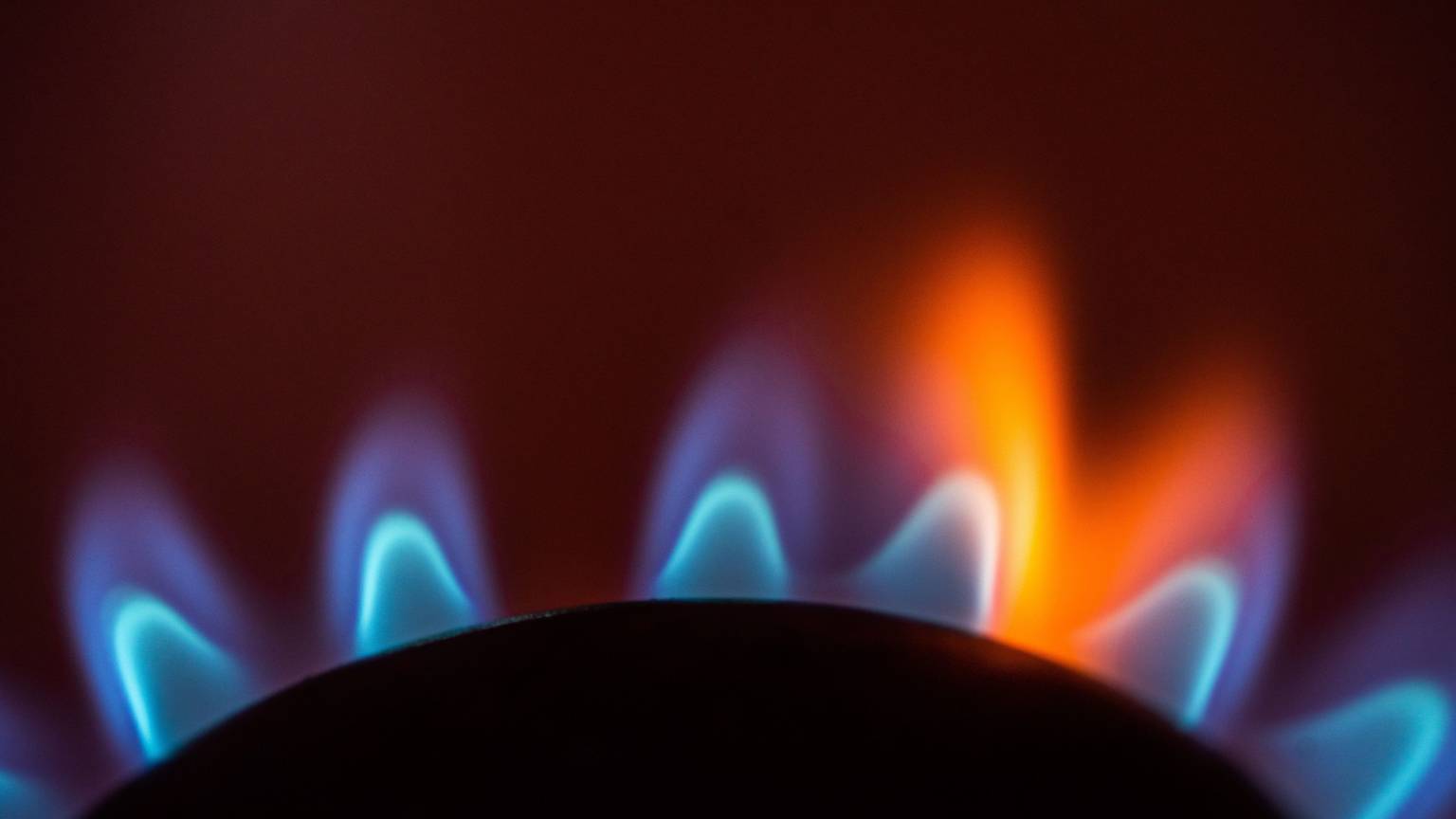 Die Flamme eines Gasherdes brennt in einer Küche.