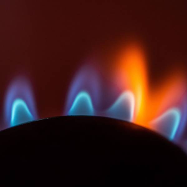 Die Flamme eines Gasherdes brennt in einer Küche.