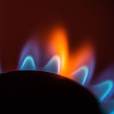 Die Flamme eines Gasherdes brennt in einer Küche.