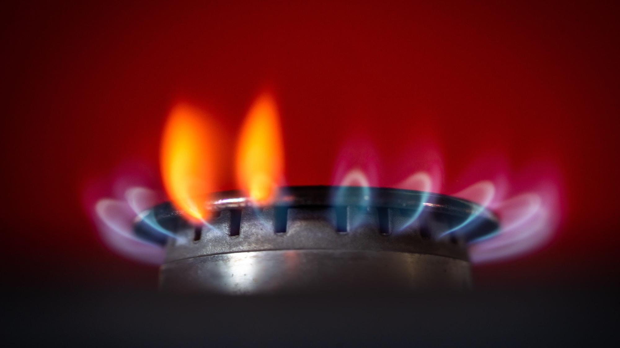 Die Flamme eines Gasherdes brennt in einer Küche.