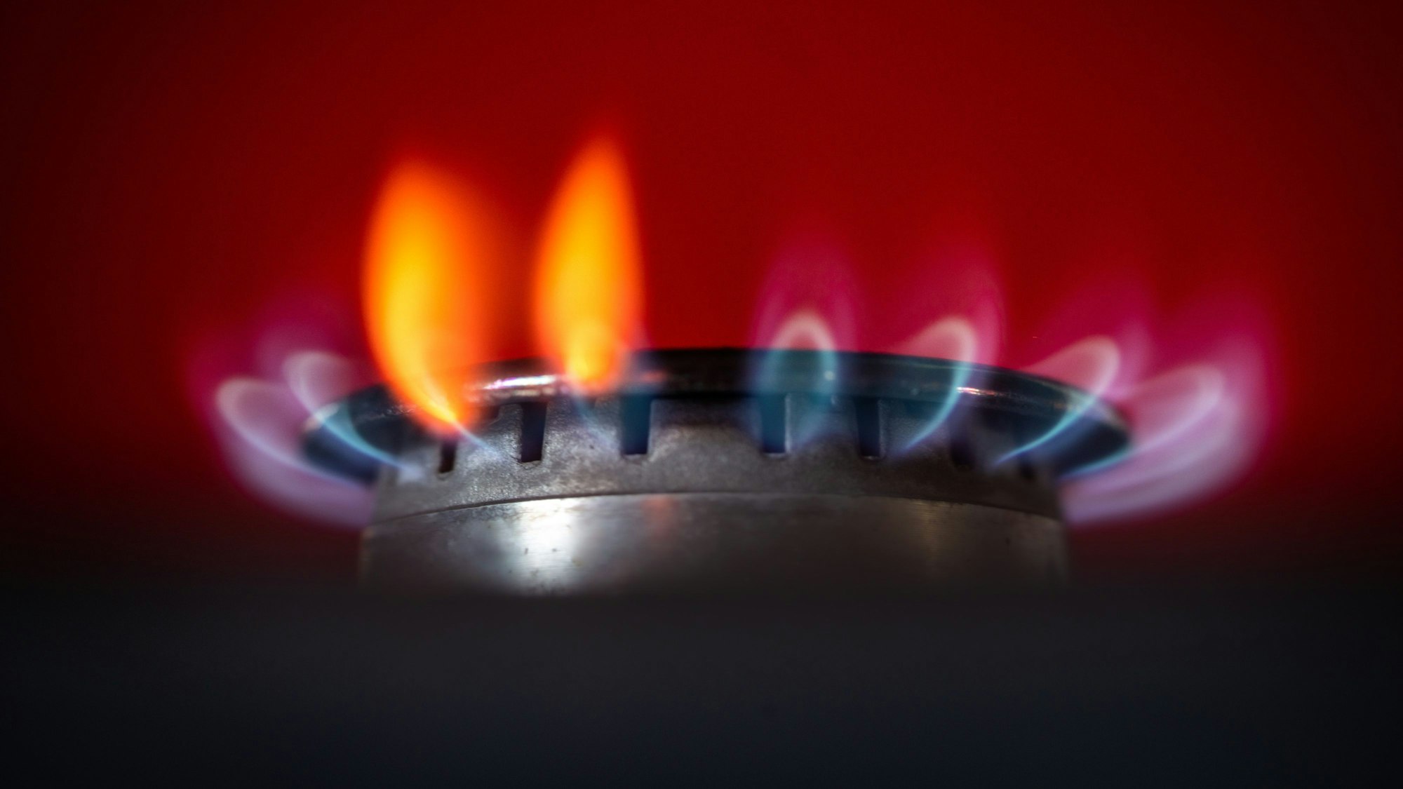 Die Flamme eines Gasherdes brennt in einer Küche.