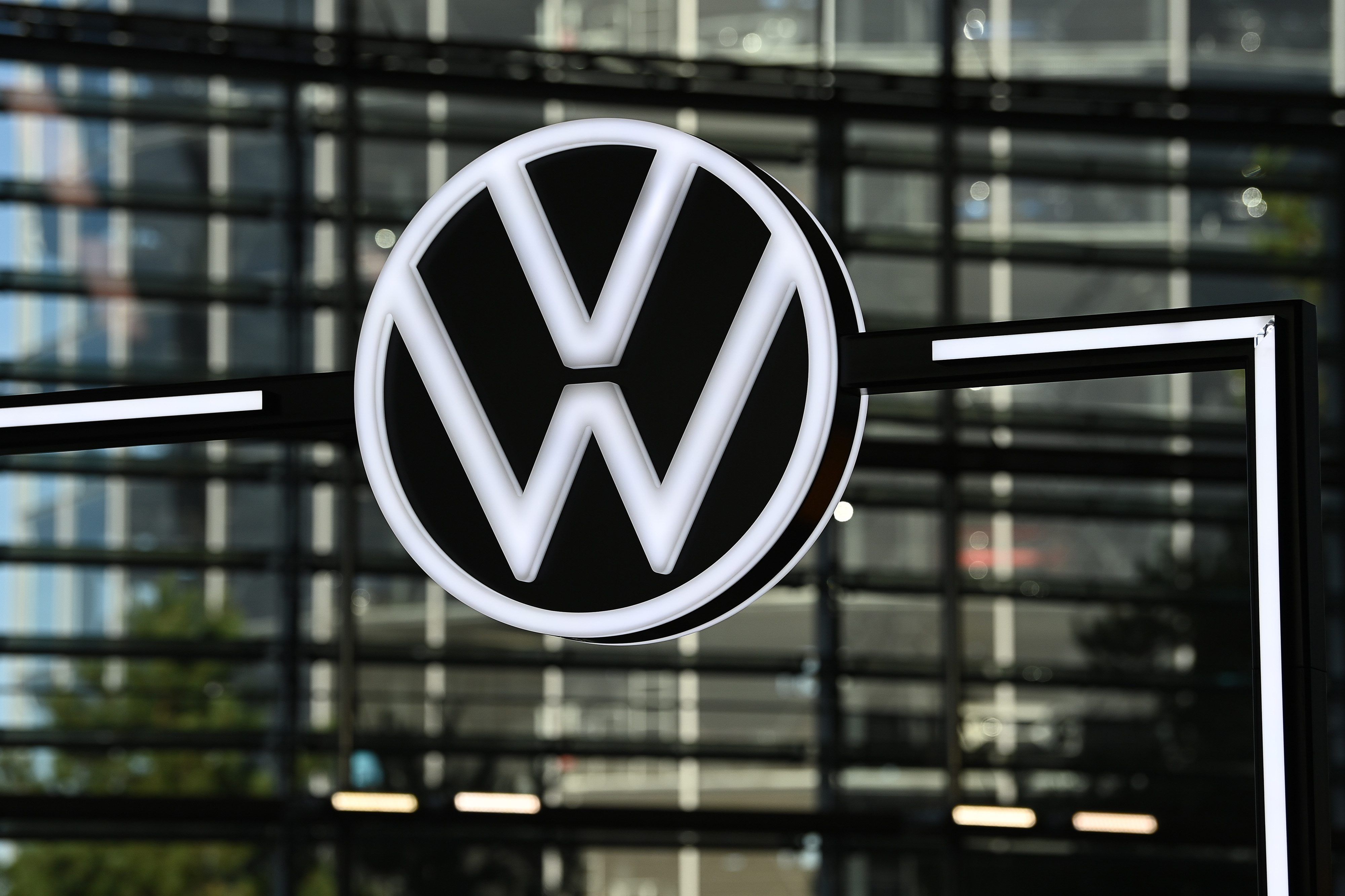 Ein Volkswagen Logo vor einer Glasfassade.