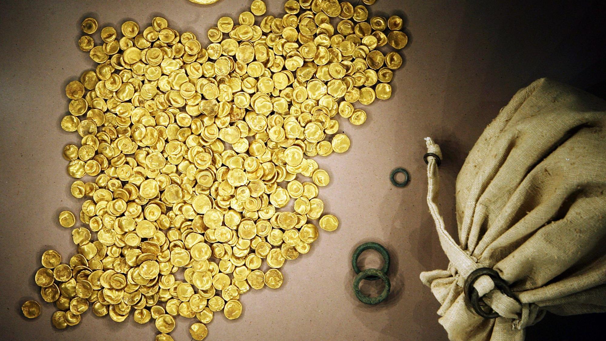 Viele Goldmünzen und ein Säckchen als Behälter sind zu sehen, die Münzen strahlen leuchtend-gold.