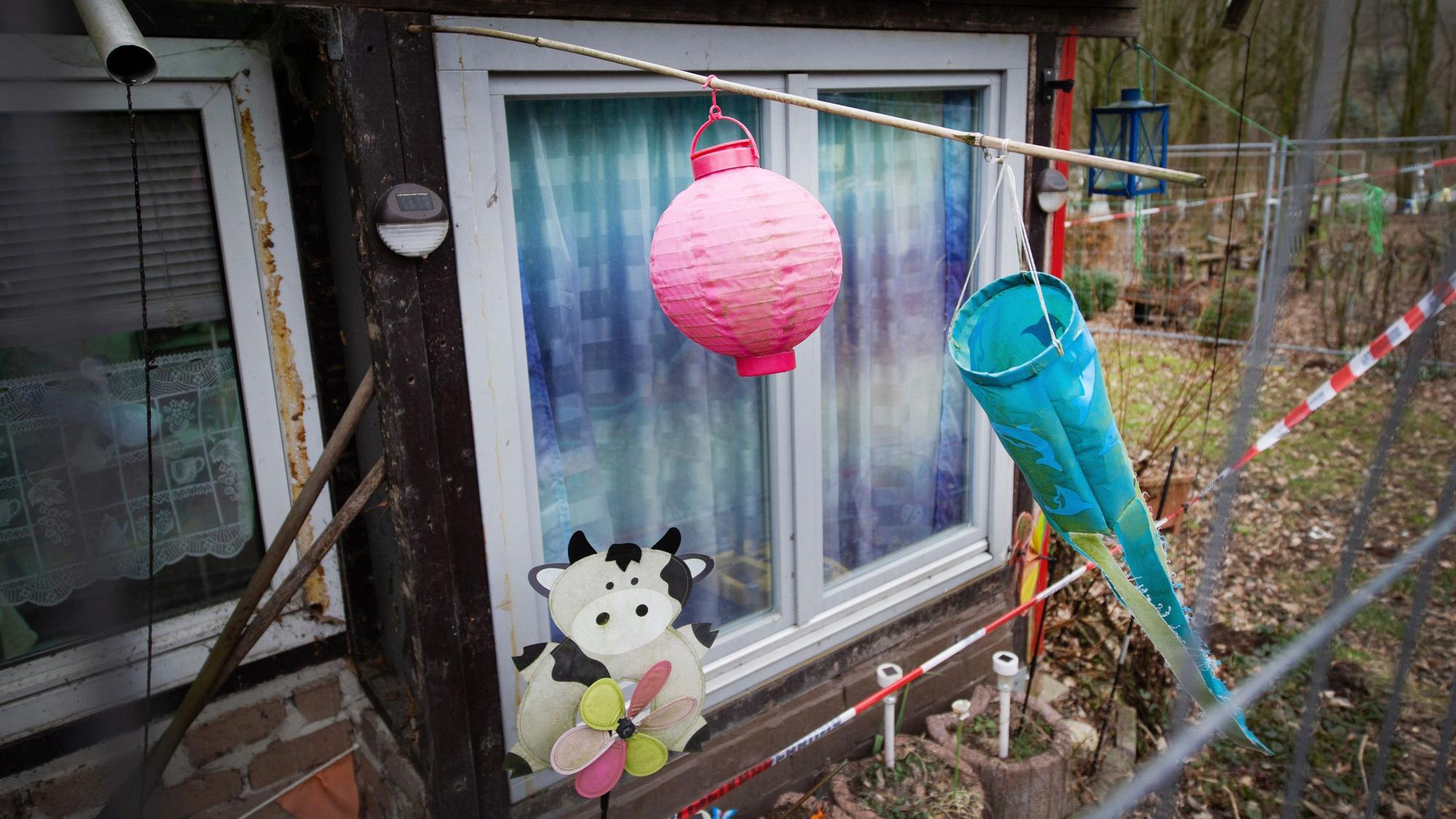 Hinter einem Zaun und Polizeiabsperrband ist ein Lampion und ein Windspiel auf dem Campingplatz Eichwald zu sehen. Der Untersuchungsausschuss des Düsseldorfer Landtags zum sexuellen Kindesmissbrauch in Lügde setzt am Freitag seine Zeugenvernehmungen fort.