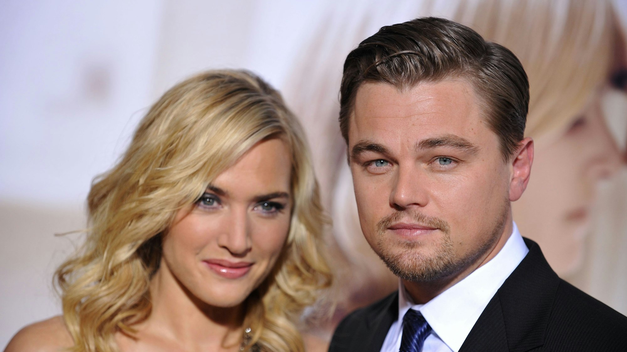 Kate Winslet und Leonardo DiCaprio auf dem roten Teppich. Sie schauen die Fotografen lächelnd an.