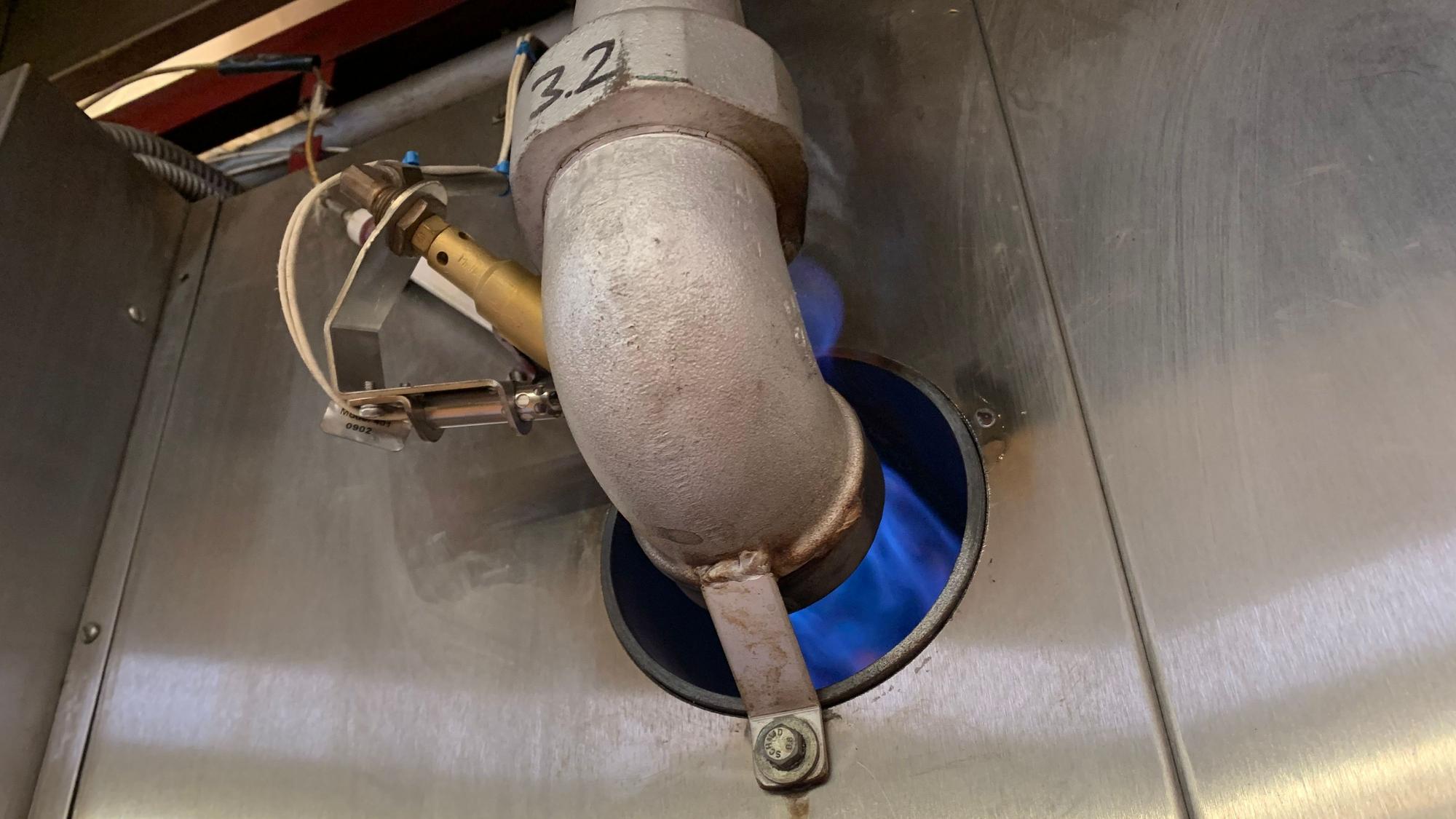 Ein blaue Gasflamme beheizt den Keksofen in der Fabrik.