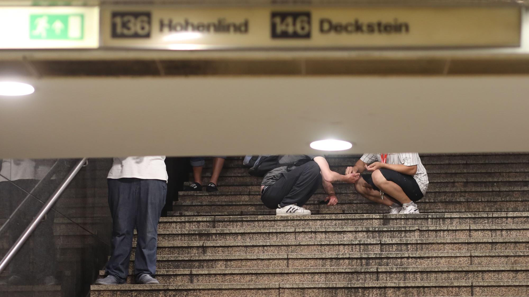 An der Passage am Neumarkt: Dealer und Konsumenten treffen aufeinander. Zwei Passanten auf der Treppe zur U-Bahn.