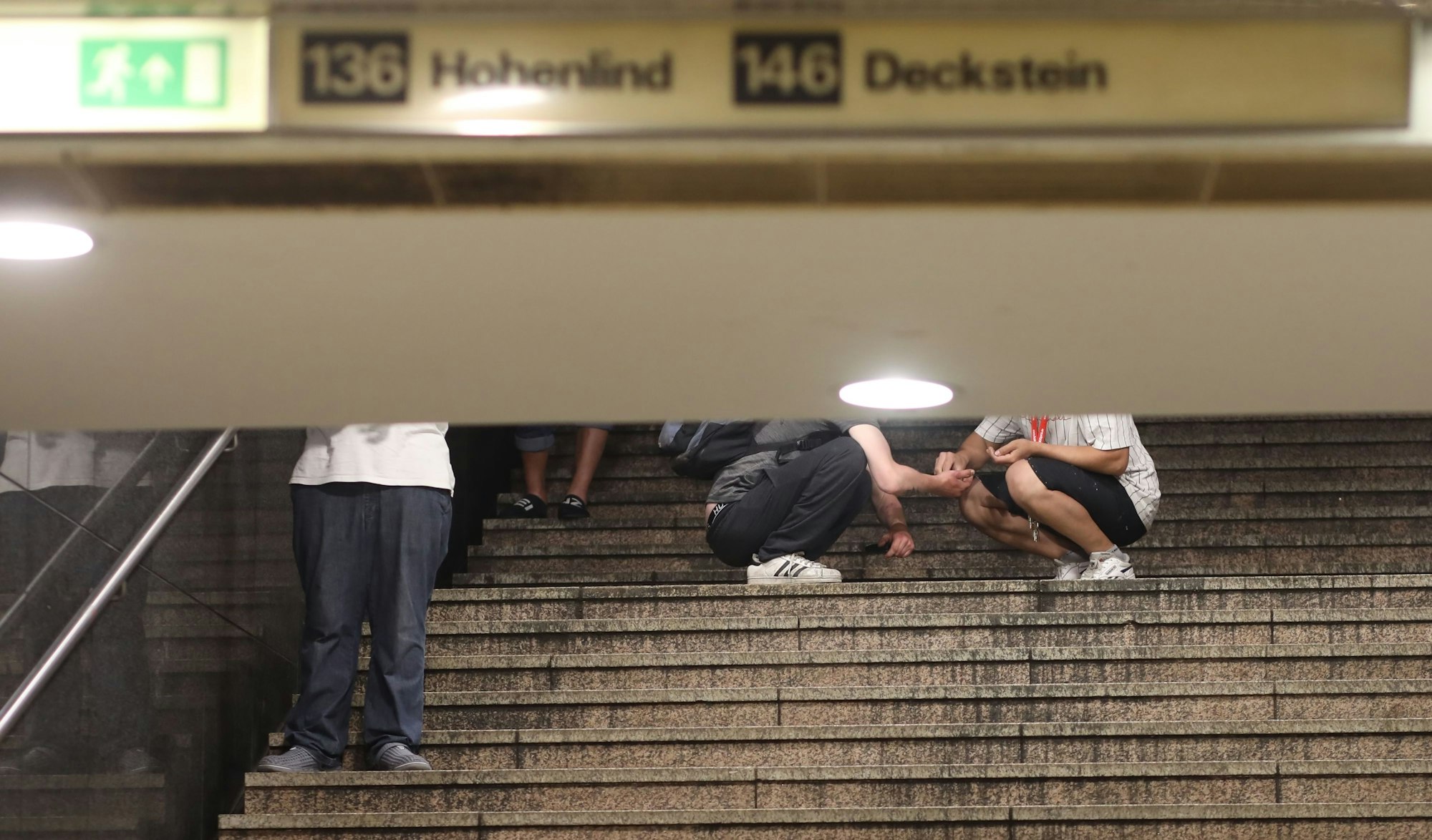 Das Bild zeigt, wie an der Hugo-Passage am Neumarkt Dealer und Konsumenten auf einer Treppe aufeinandertreffen.