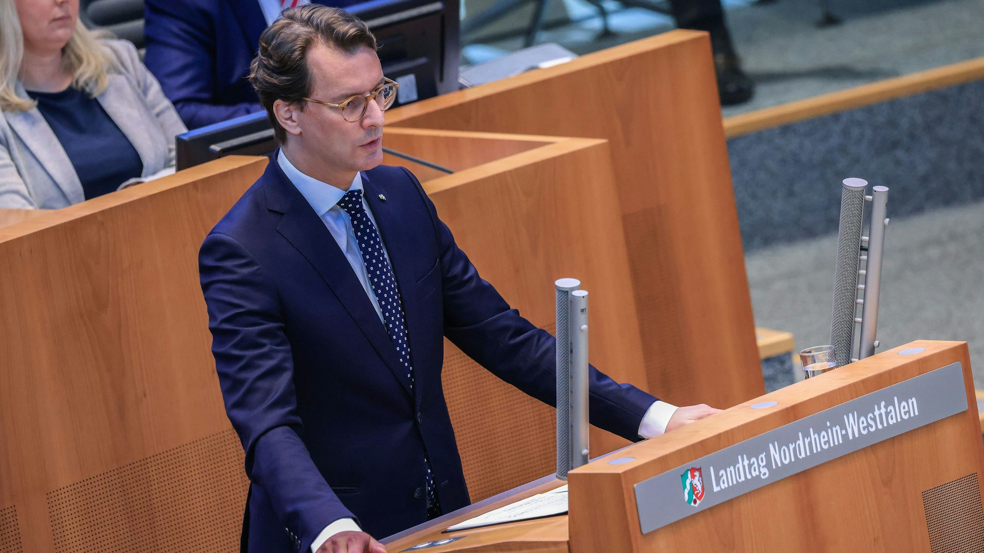 Hendrik Wüst, NRW-Ministerpräsident, steht am Rednerpult des Plenums. Er trägt einen dunkelblauen Anzug. Wüst spricht während der aktuellen Stunde im Landtag über die Schüsse auf die Alte Synagoge in Essen.