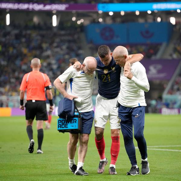 Frankreichs Lucas Hernández wird während des WM-Spiels der Gruppe D zwischen Frankreich und Australien im Al-Janoub-Stadion in Al Wakrah, Katar, vom Platz gebracht. Zwei Mitarbeiter des Ärzeteteams stützen ihn.