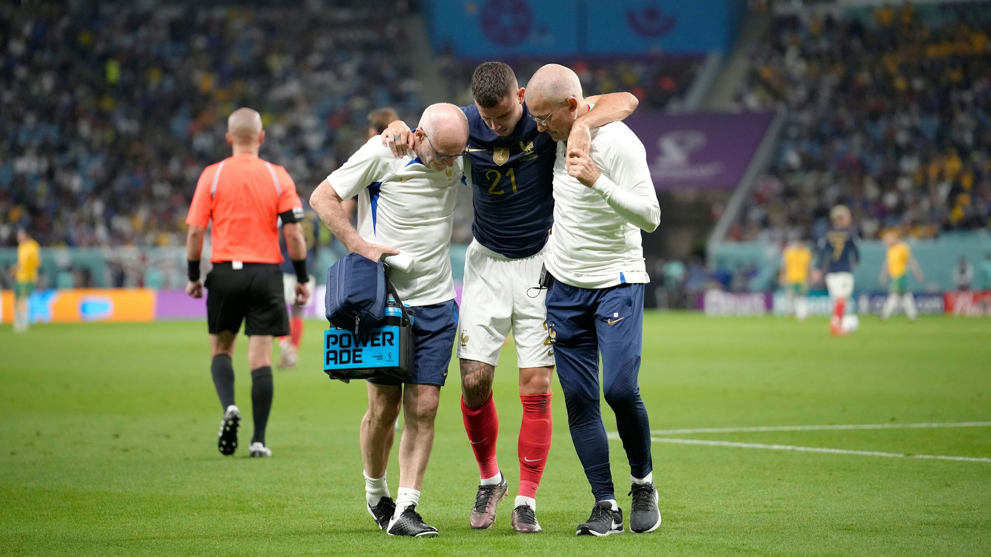 Frankreichs Lucas Hernández wird während des WM-Spiels der Gruppe D zwischen Frankreich und Australien im Al-Janoub-Stadion in Al Wakrah, Katar, vom Platz gebracht. Zwei Mitarbeiter des Ärzeteteams stützen ihn.