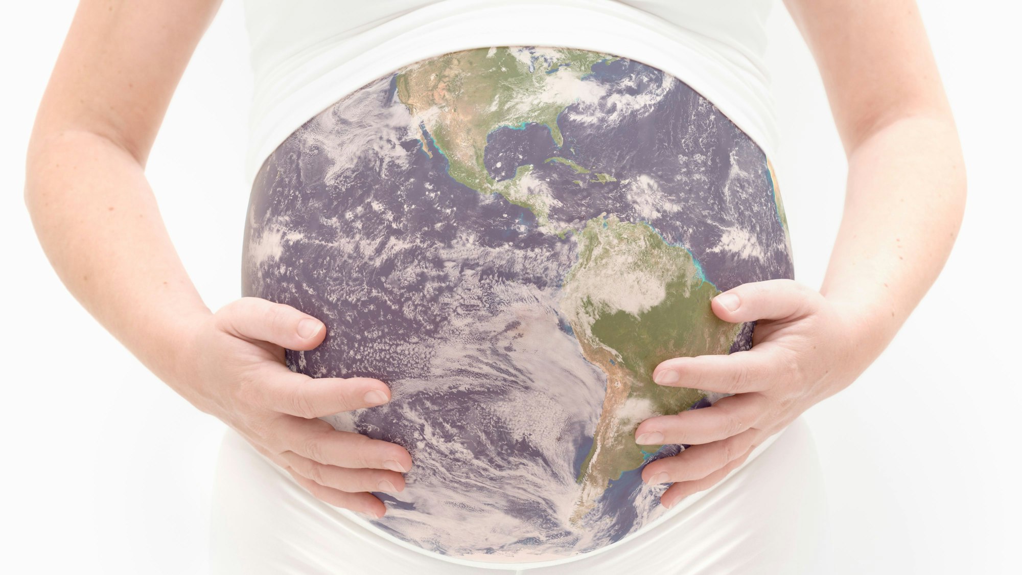 Eine schwangere Frau hält ihren Bauch, der aussieht wie die Erdkugel.