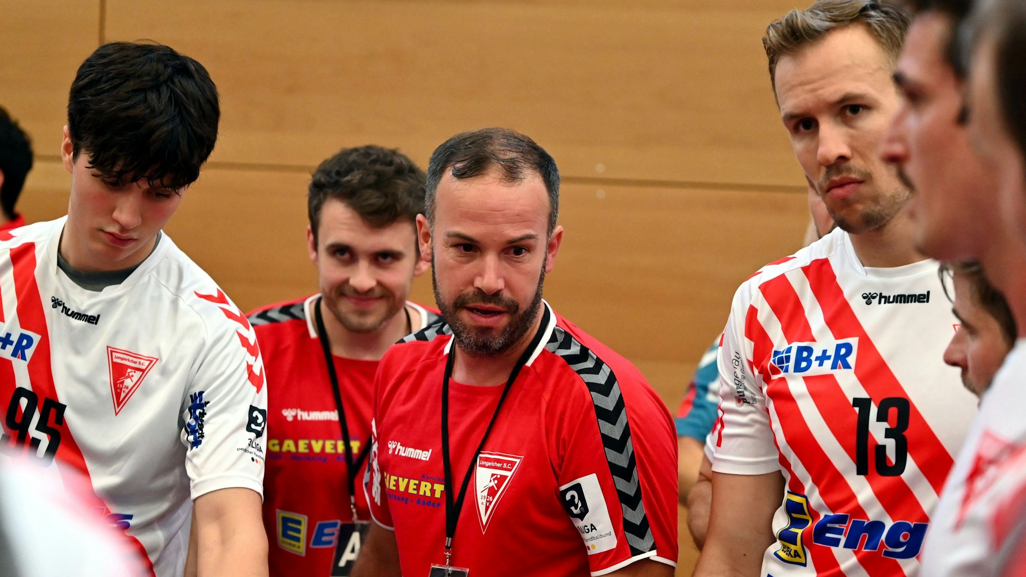 Ein Handballtrainer gibt seiner Mannschaft während einer Auszeit Anweisungen.