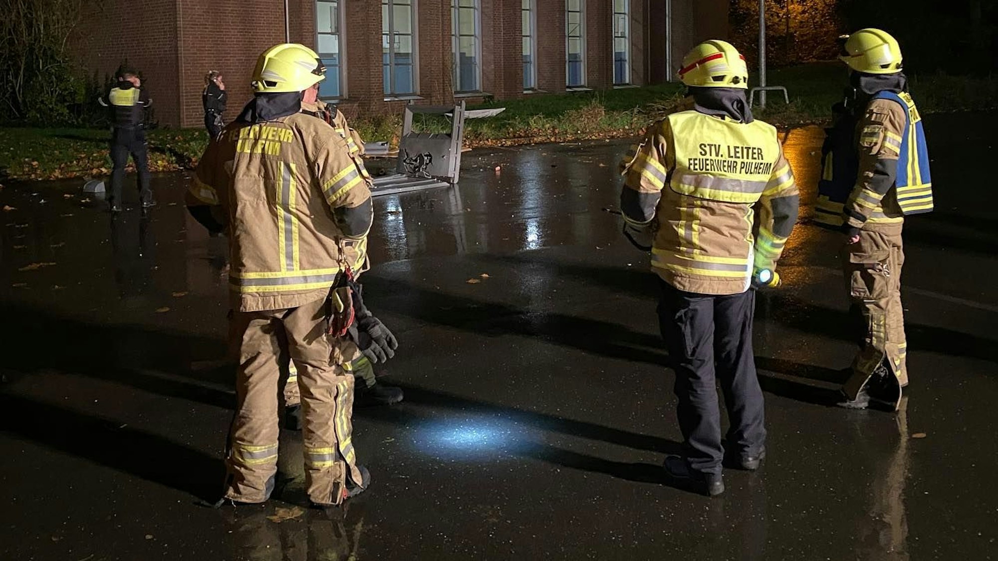 Feuerwehrleute betrachten das gesprengte, weiße Dixi-Klo.