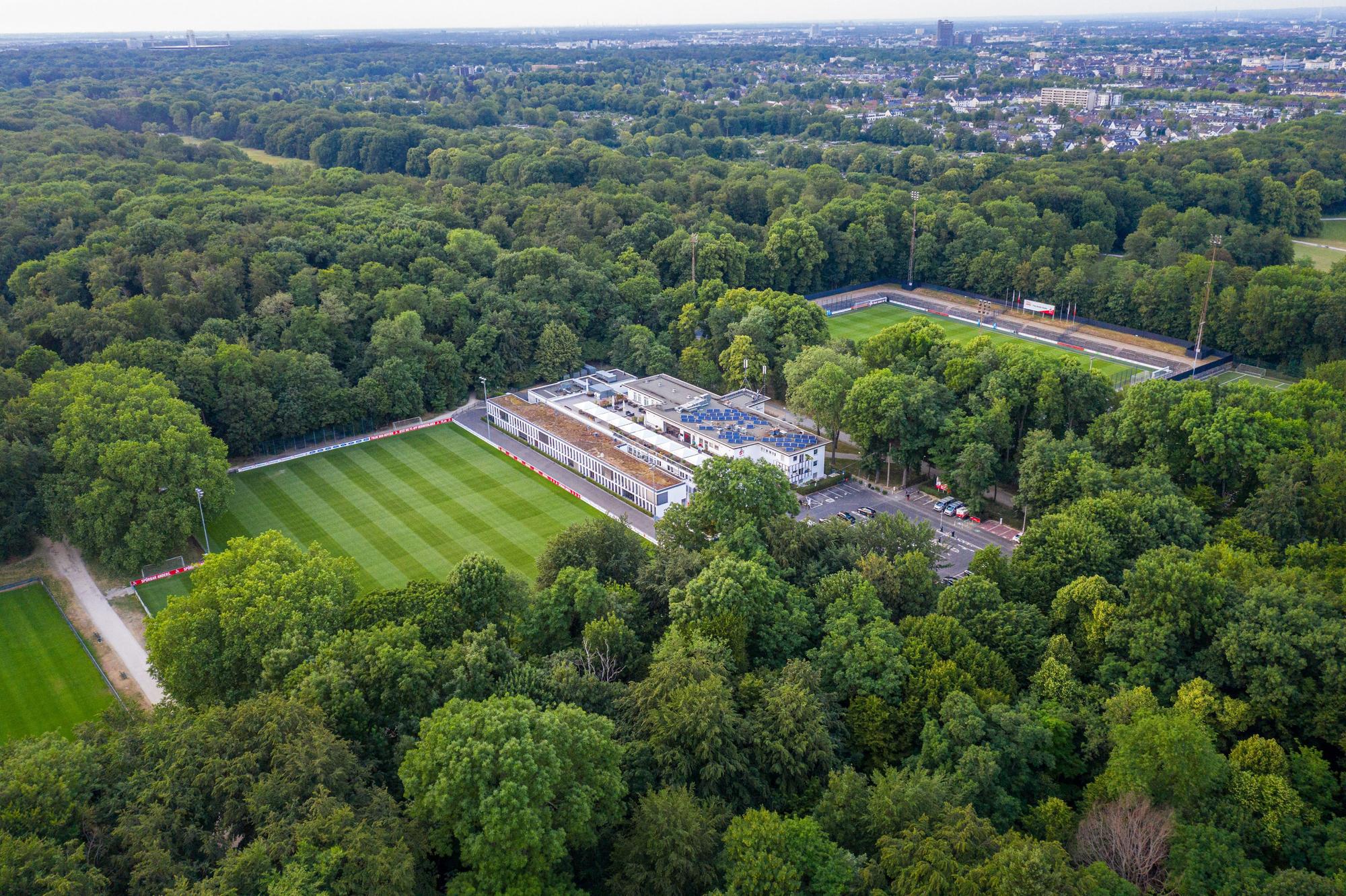 Das Bild zeigt das Geißbockheim mit dem Trainingsplatz 1 (links) und dem Franz-Kremer-Stadion (rechts) im Äußeren Grüngürtel.