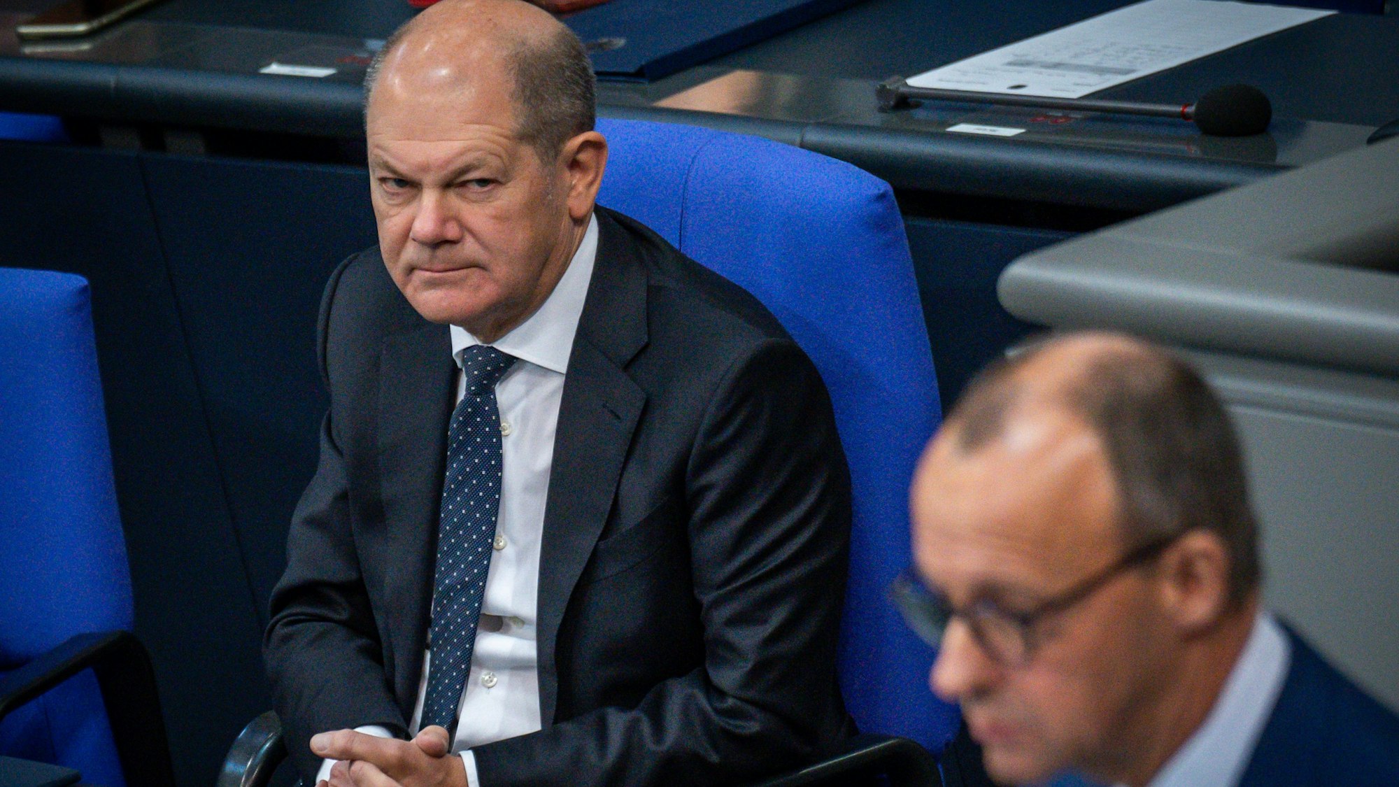 Bundeskanzler Olaf Scholz (SPD) beobachtet Friedrich Merz, CDU Bundesvorsitzender, im Bundestag in der Generaldebatte der Haushaltswoche.