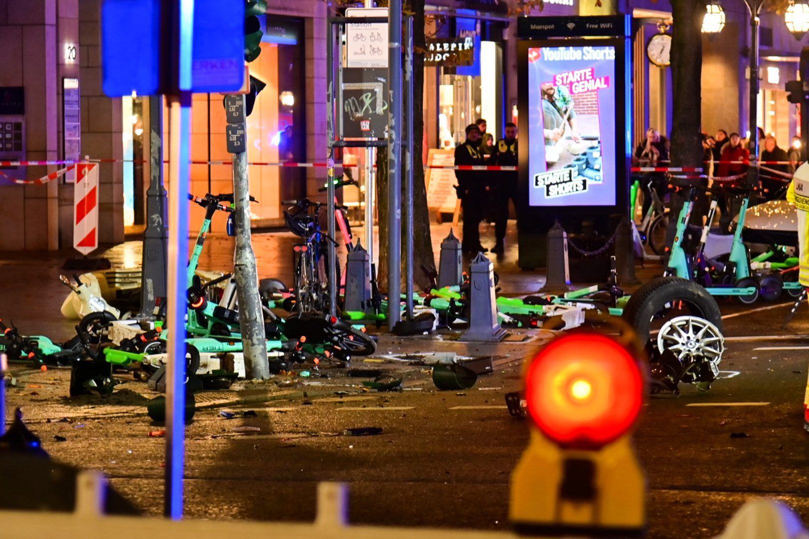 Flatterband sichert die Unfallstelle rund um stehende und liegende E-Scooter auf der Königsallee.