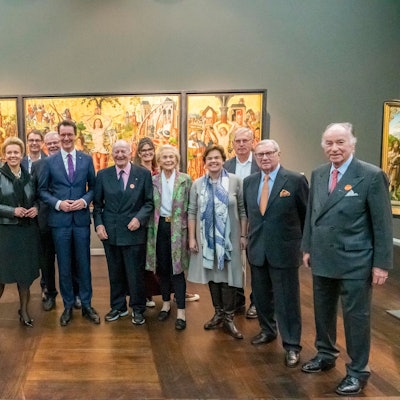 Ministerpräsident Hendrik Wüst und Mitglieder des Stifterrats stehen im Wallraf-Richartz-Museum vor einem mittelalterlichen Gemälde.