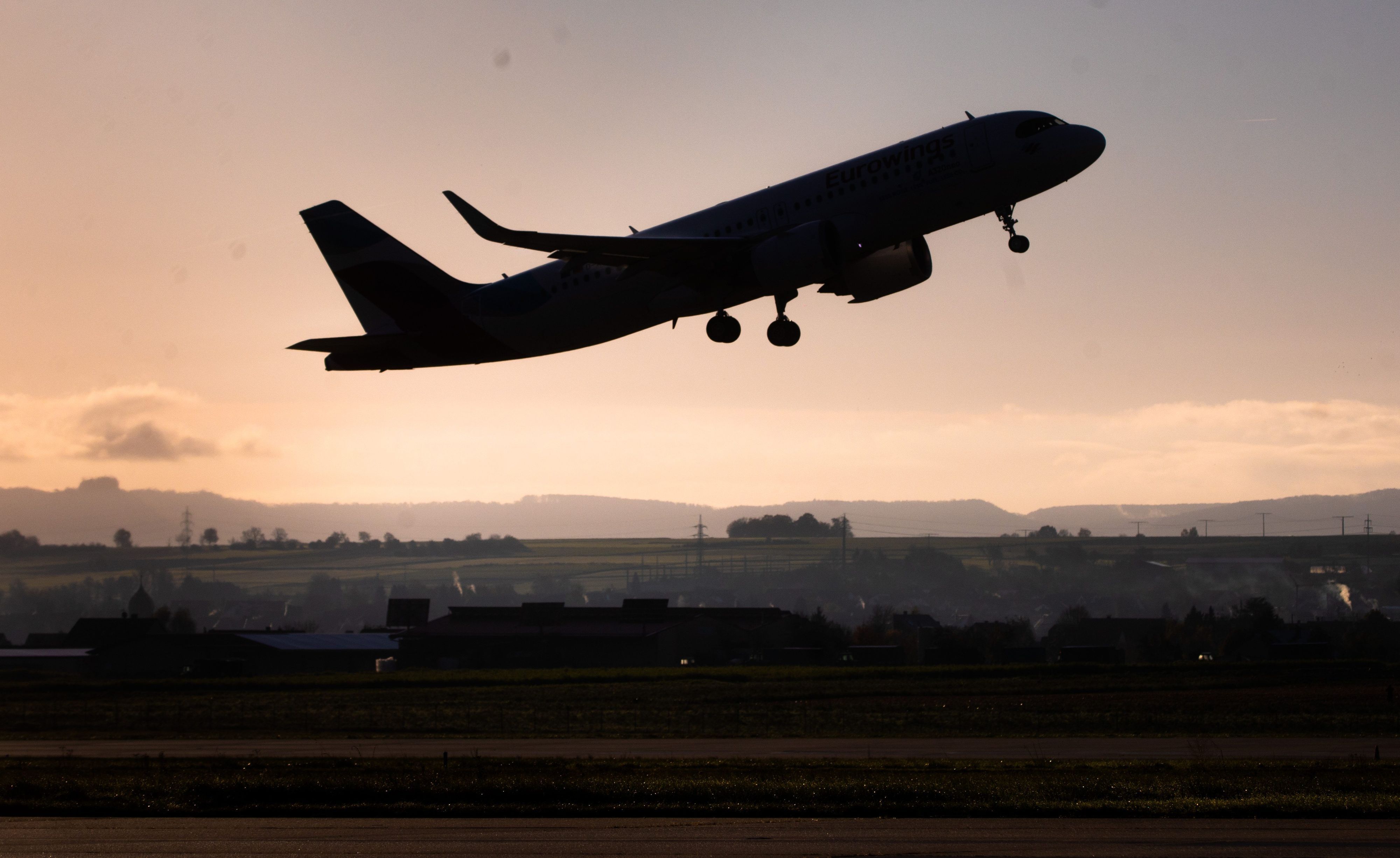 Ein Flugzeug hebt im Morgengrauen vom Stuttgarter Flughafen ab.