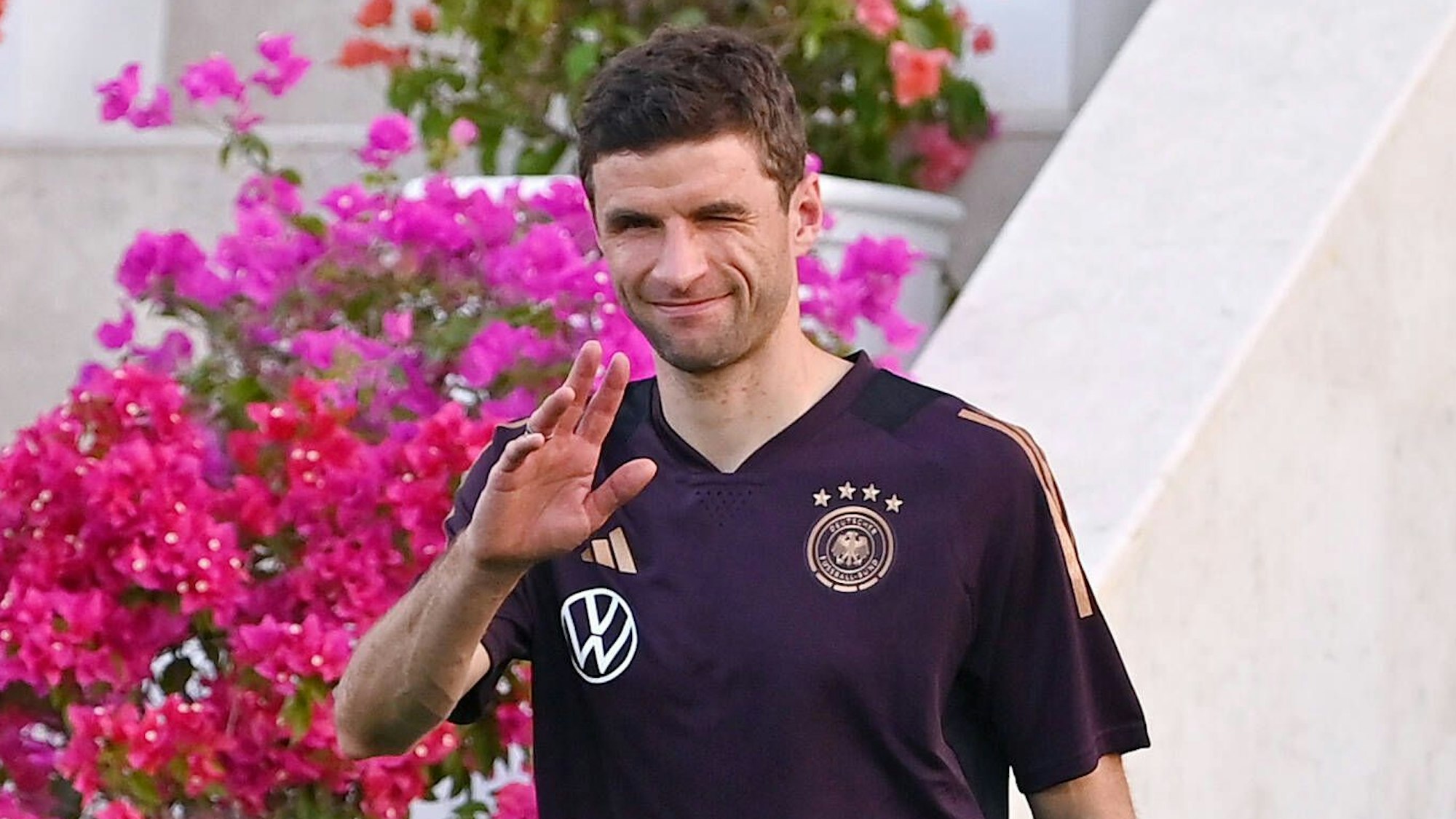 Thomas Müller kommt vor einem Testspiel der deutschen Nationalmannschaft gegen den Oman ins Stadion und grüßt in Richtung Kamera.