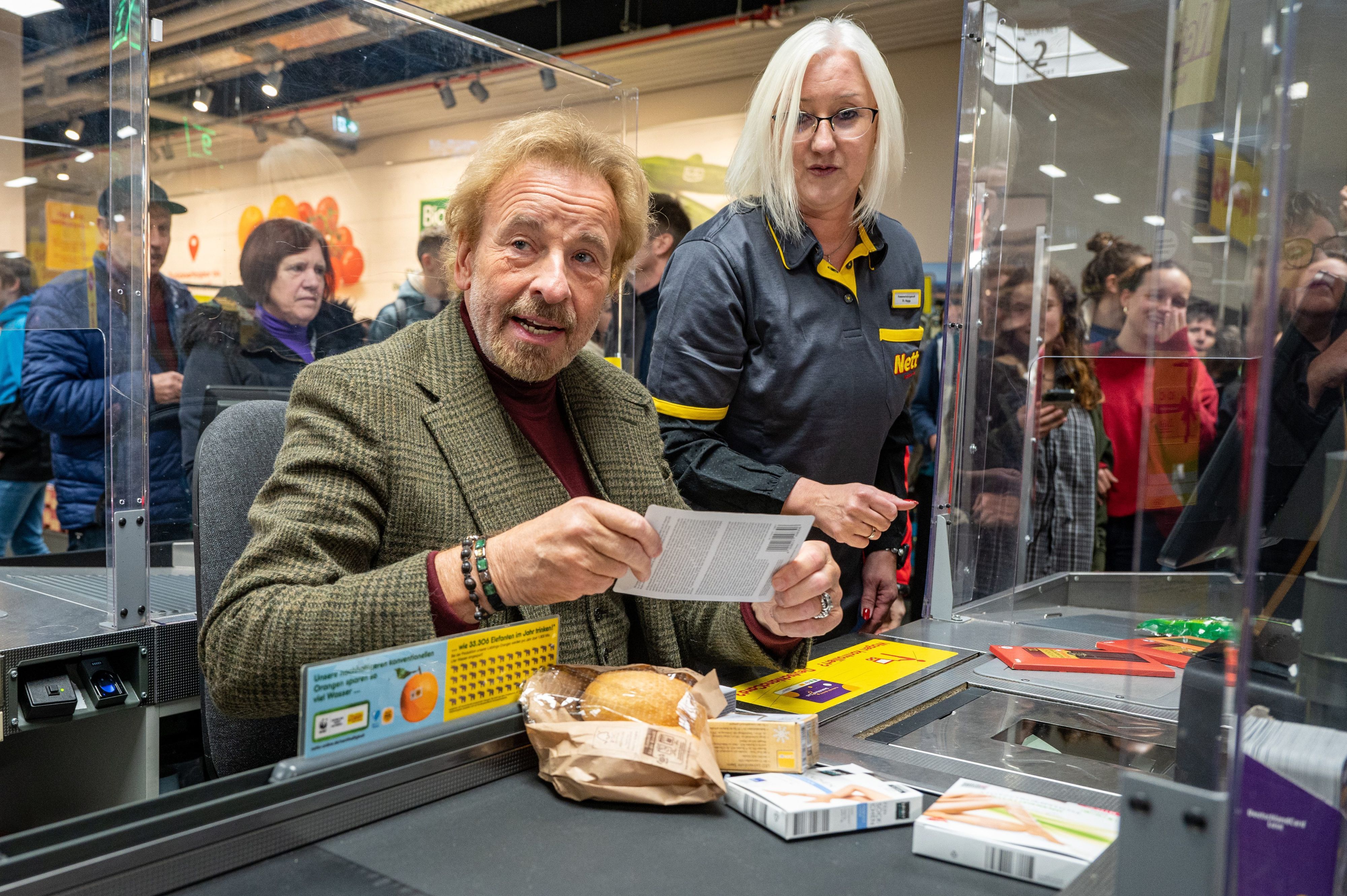 Thomas Gottschalk sitzt an einer Supermarkt-Kasse in Regensburg.