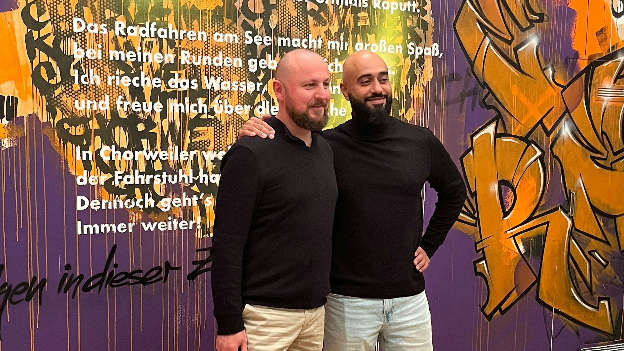 Damian Zimmermann (l.) und Puya Bagheri stehen vor der Graffiti-Wand im Käthe Kollwitz Museum.