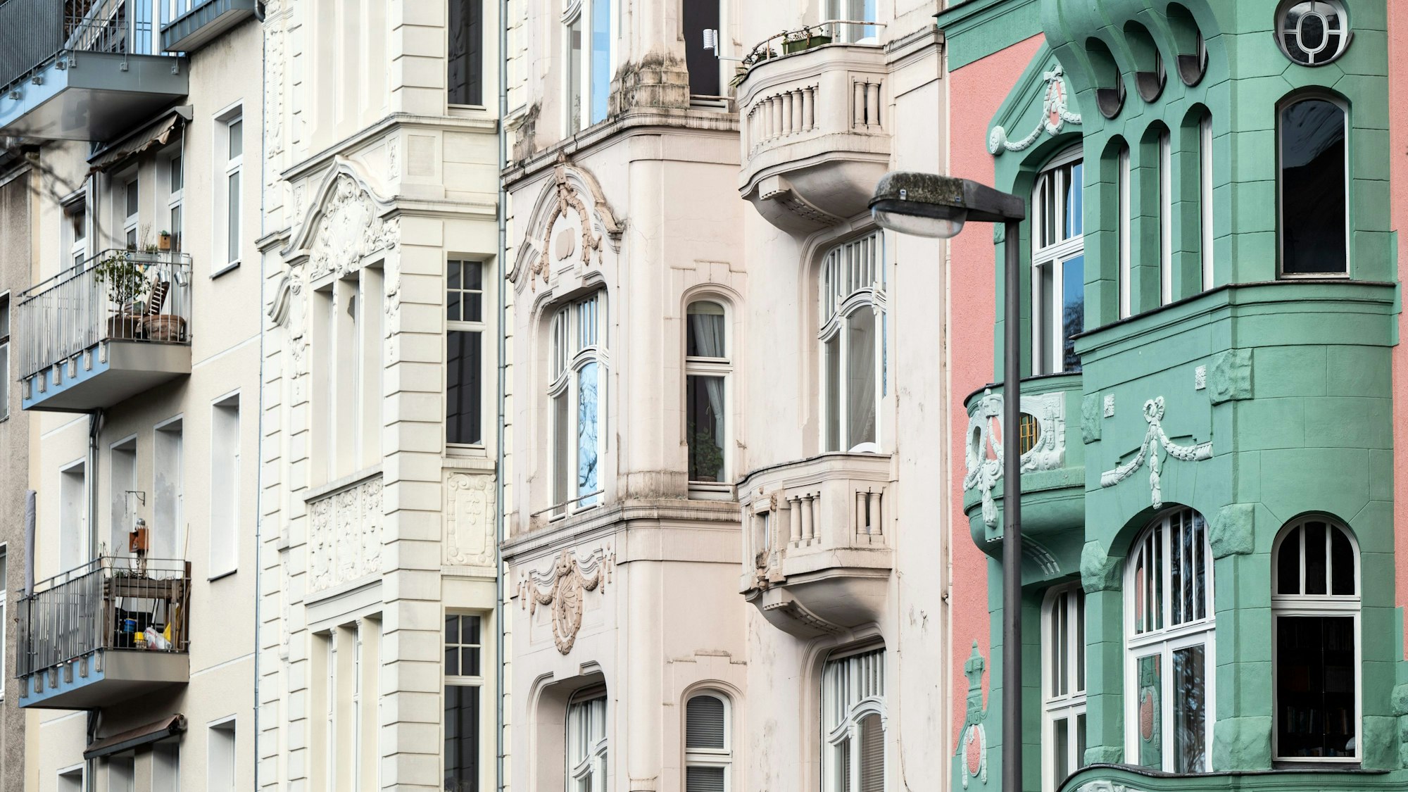 Zu sehen sind in unterschiedlichen Farben gestrichene Altbaufassaden in Köln.