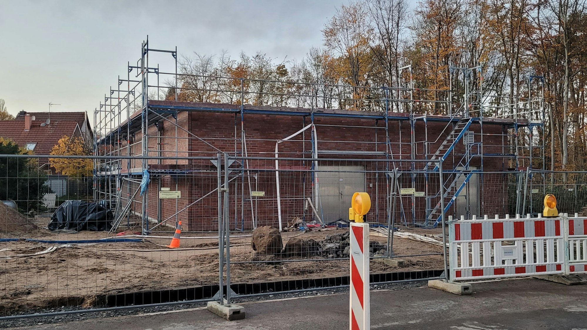 Gerüste und Absperrungen stehen vor einem Wasserstationsgebäude.