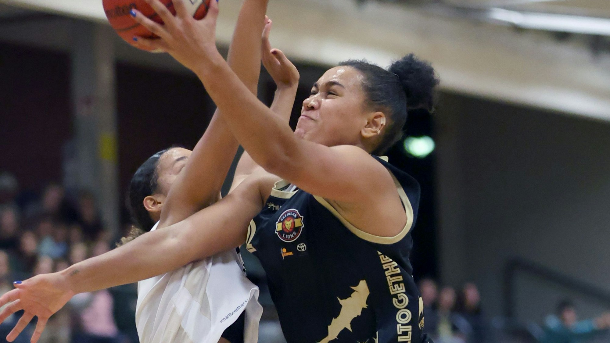 Mit dem Ball in der Hand setzt sich die Rheinland Lions Spielerin Anna Lappenküper gegen ihre Gegenspielerin unter dem Korb durch.