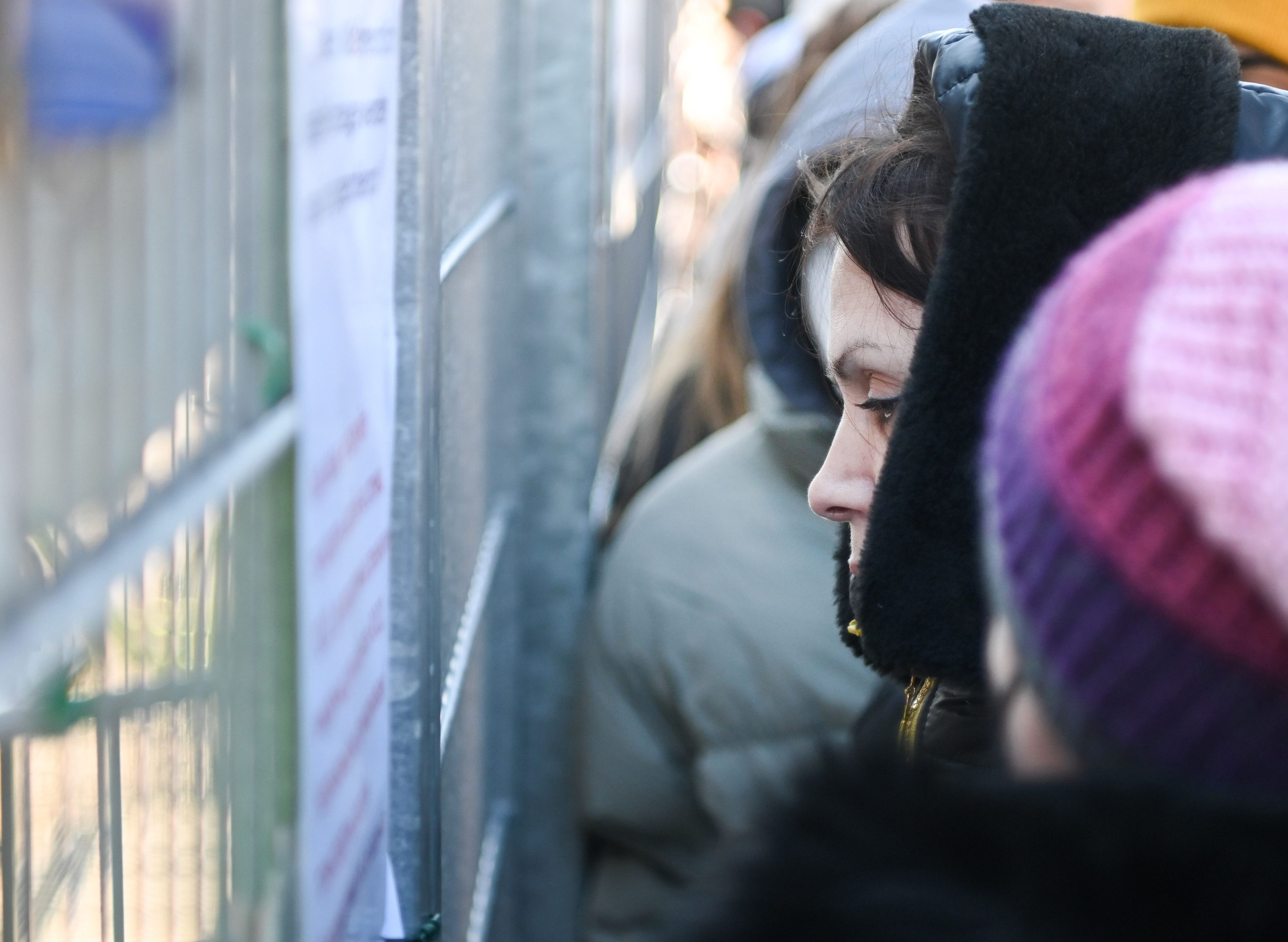 Geflüchtete warten vor einer Flüchtlingsunterkunft auf Einlass.