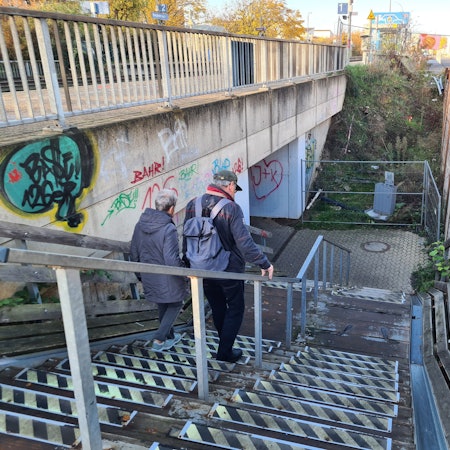 Pendler steigen die Treppe vom Bahngleis zur Unterführung des Bahnhofs hinab.