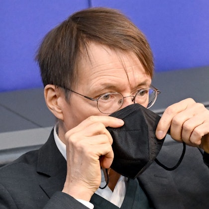 Bundesminister für Gesundheit, setzt seine Maske nach seiner Rede bei der Sitzung im Bundestag wieder auf.