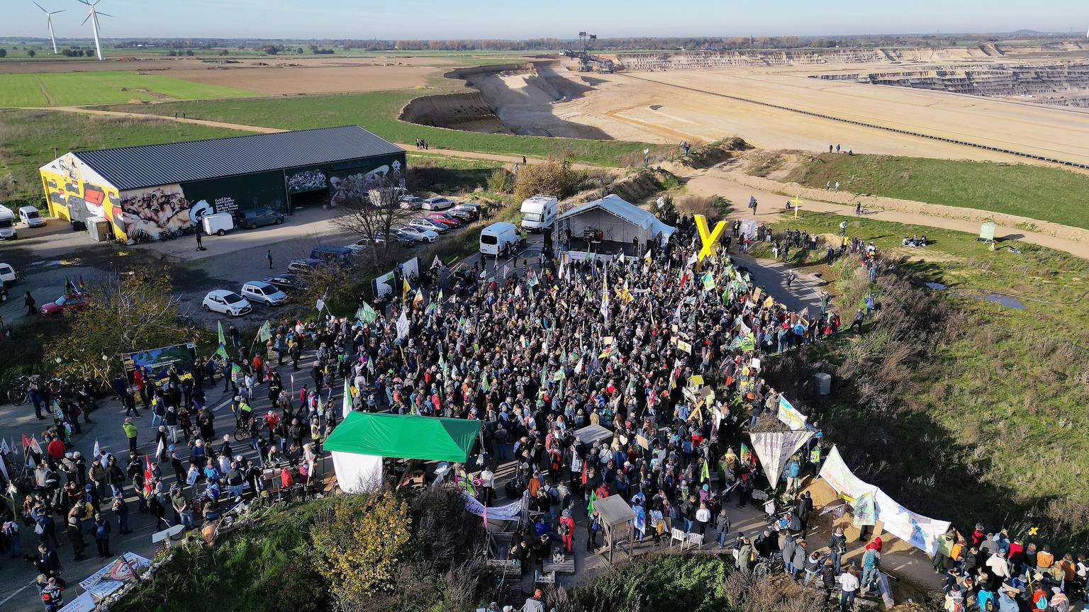 06.11.2022, Nordrhein-Westfalen, Erkelenz: Demonstrationsteilnehmer dicht an der Kante des Tagebaues. (Aufnahme mit einer Drohne) Foto: David Young/dpa +++ dpa-Bildfunk +++