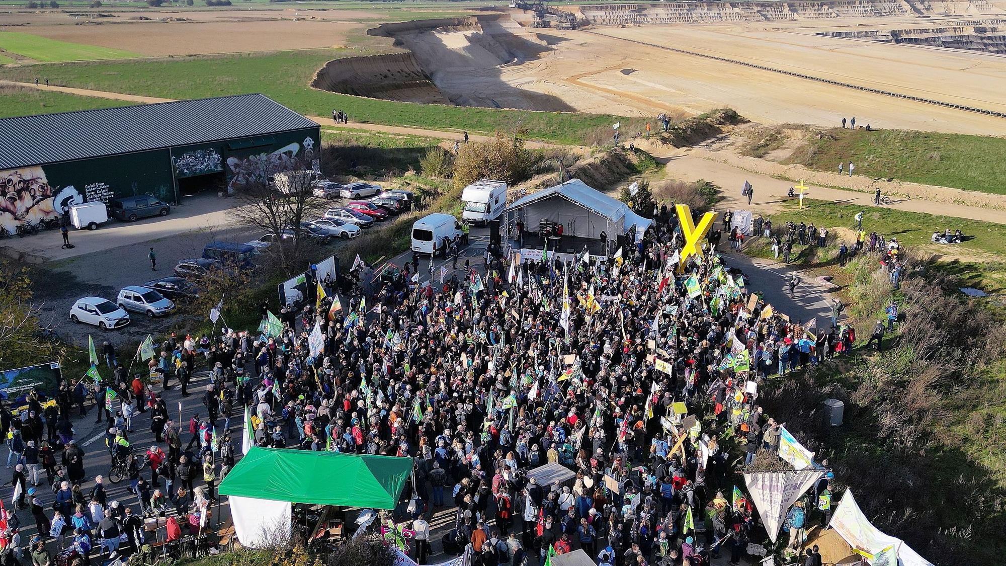 Die Drohnenaufnahme zeigt Demonstrationsteilnehmer dicht an der Kante des Tagebaues bei Erkelenz.