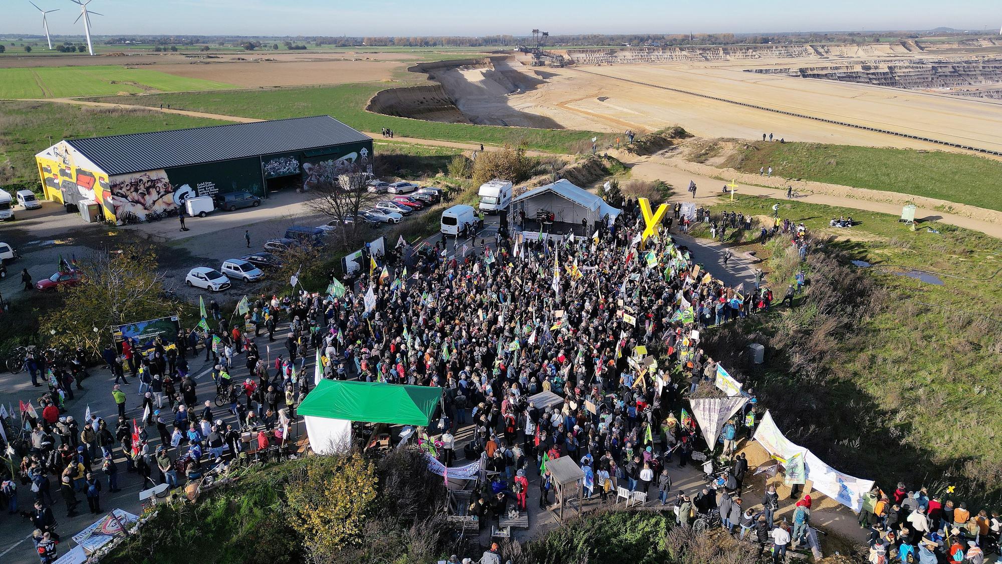 06.11.2022, Nordrhein-Westfalen, Erkelenz: Demonstrationsteilnehmer dicht an der Kante des Tagebaues. (Aufnahme mit einer Drohne) Foto: David Young/dpa +++ dpa-Bildfunk +++