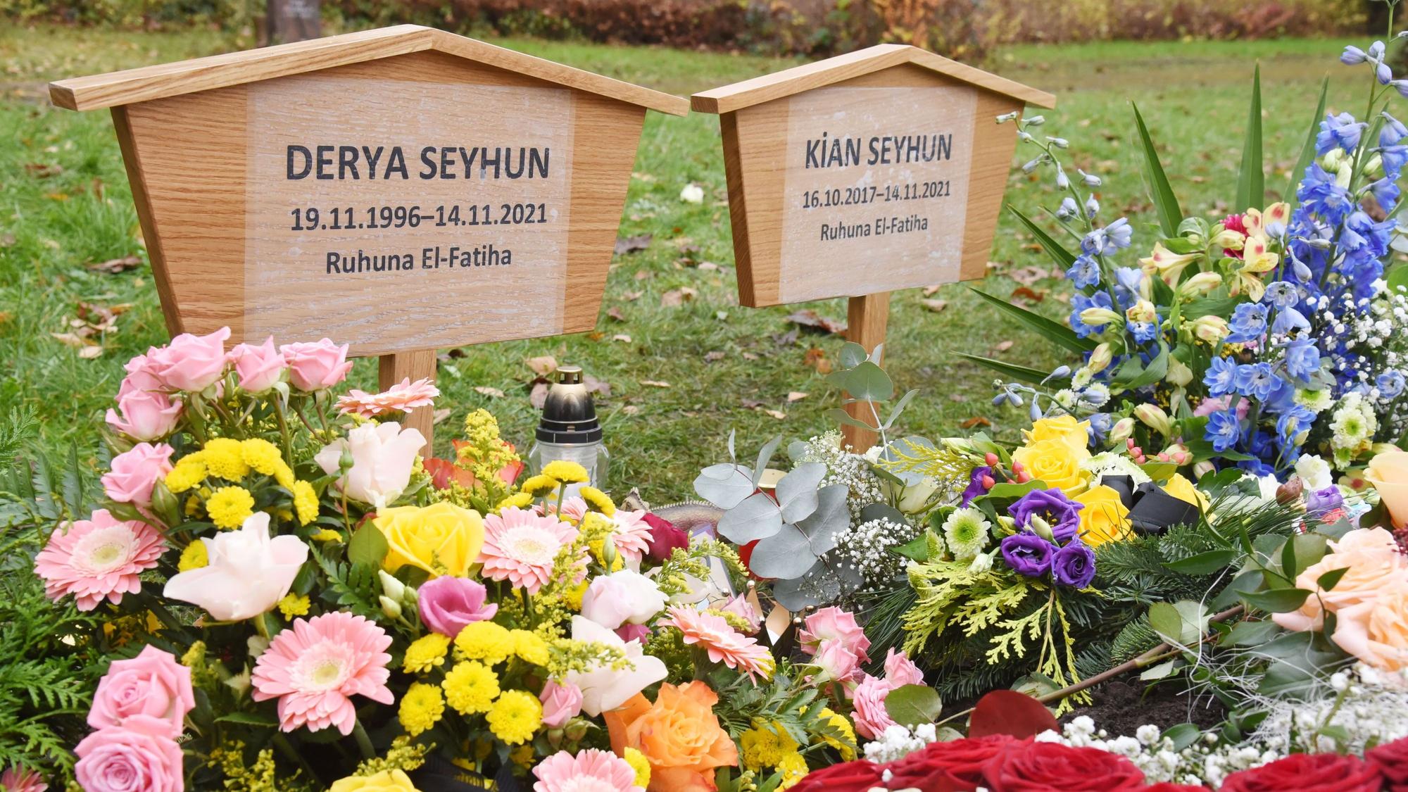 Zwei Holzkreuze stehen auf dem mit Blumen geschmückten Grab von Derya und Kian Seyhun auf dem Friedhof in Chorweiler.