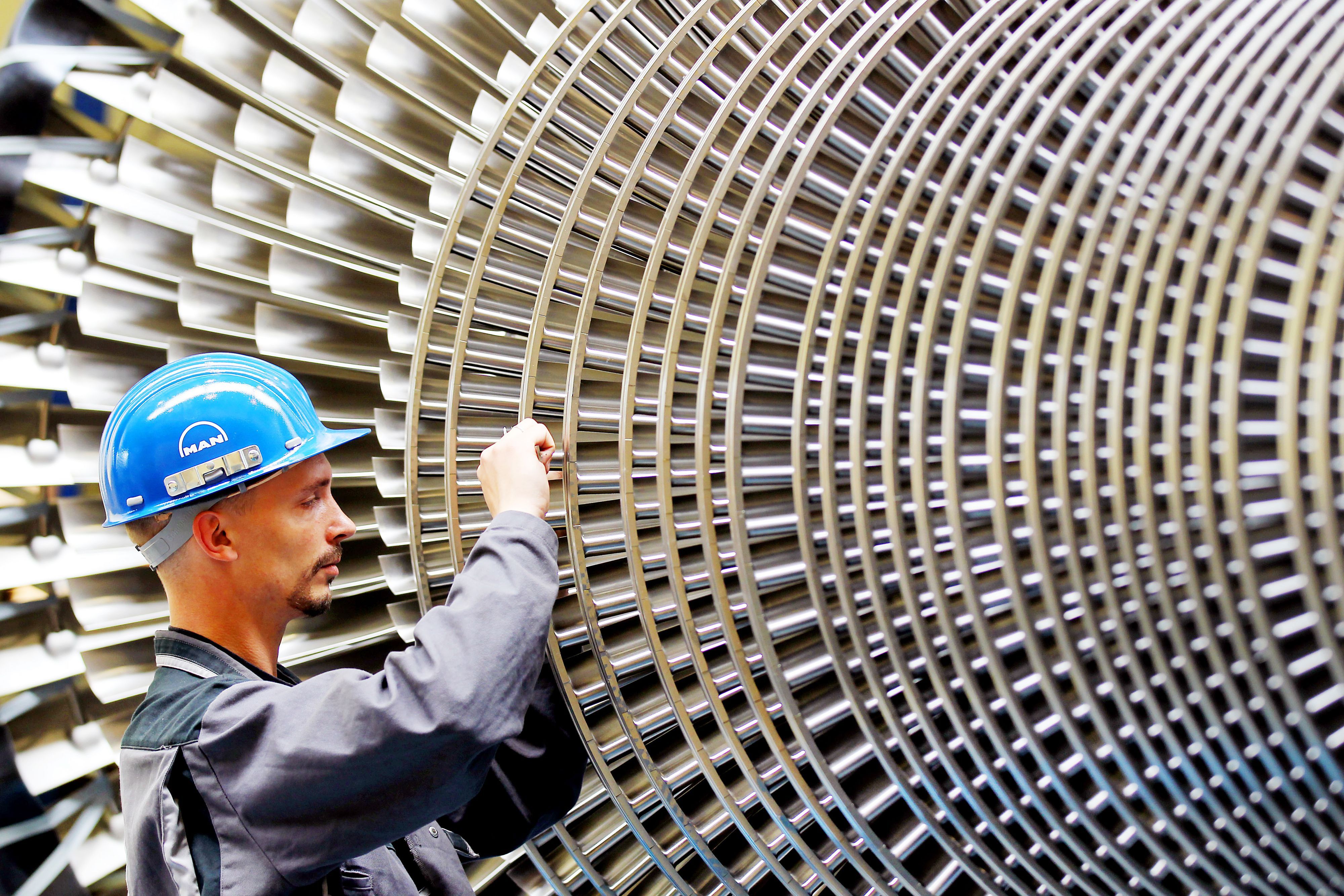 Ein Mechaniker überprüft die Schaufeln einer Turbine.