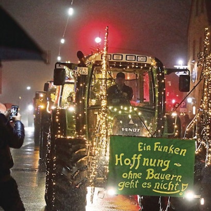 Ein leuchtender Traktor rollt mit der Aufschrift „Ein Funken Hoffnung – Ohne Bauern geht es nicht“ durch Overath-Heiligenhaus.