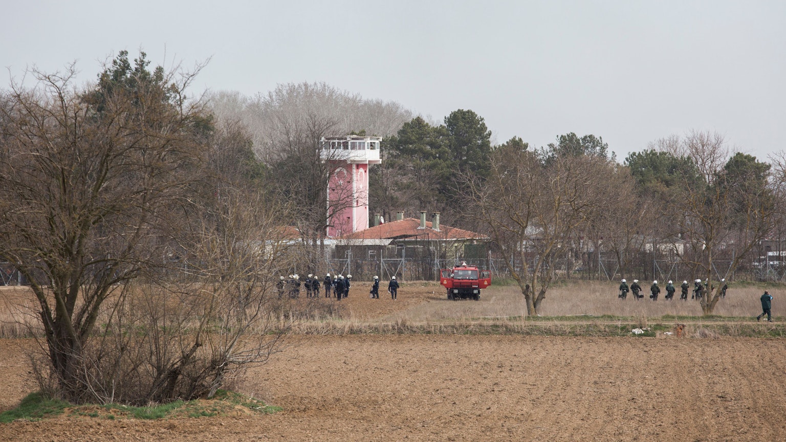 Griechische Sicherheitskräfte stehen mit Helmen und Schutzschilden ausgerüstet am Grenzzaun zur Türkei. (Symbolbild)